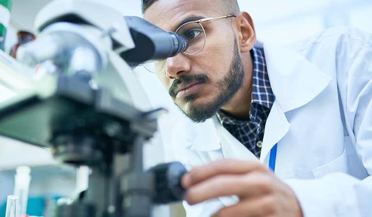 A researcher looking into a microscope