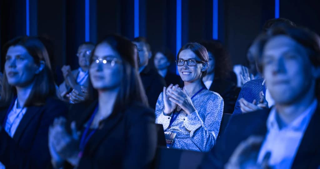 Crowd of people at a conference watching stage