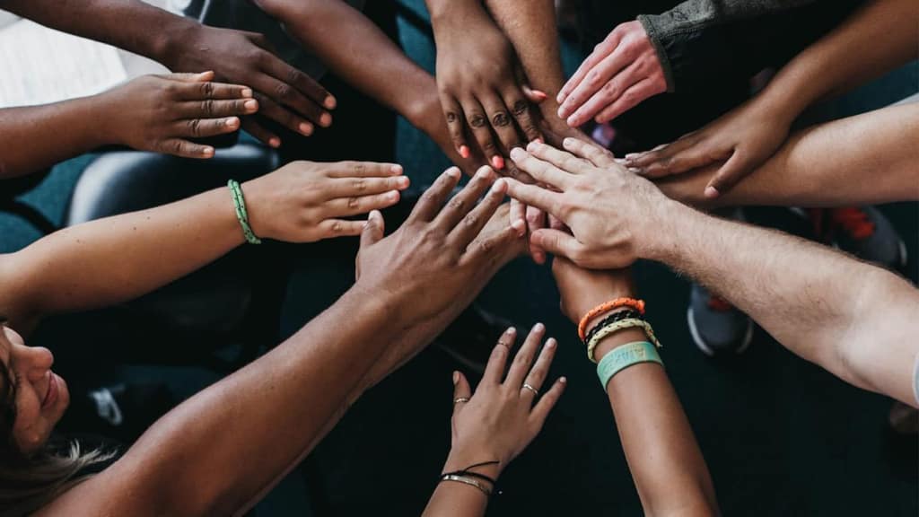 Many hands joined together in a circle
